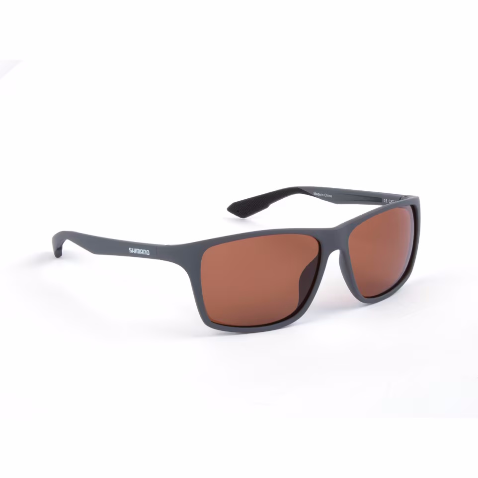 SHIMANO Technium Sonnenbrille mit mattschwarzem Matte Dark Grey Rahmen und kupferfarbenen Linsen. Polarisierte TAC-Linsen, Grilamid TR90, rutschfeste, anti-allergische Bügel für Komfort und Halt.